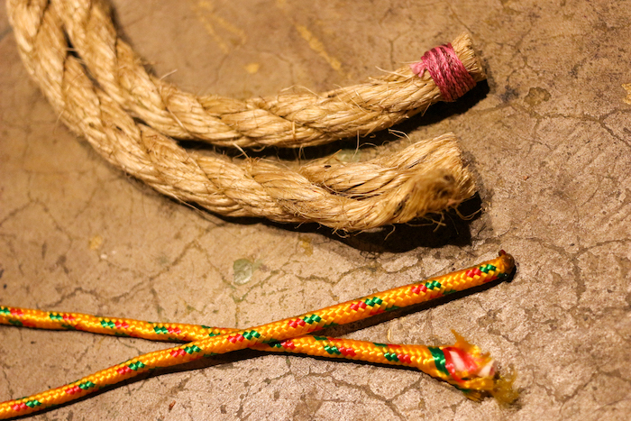 Two ropes on a concrete surface, intertwined like a fuse.