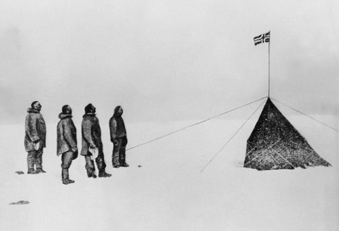 A black and white drawing of a group of people standing in the snow, achieving their goal at the South Pole.