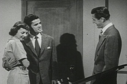 A man and a woman standing in front of a door.