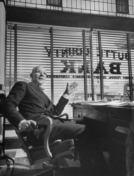 A financial man in a suit sitting at a desk.
