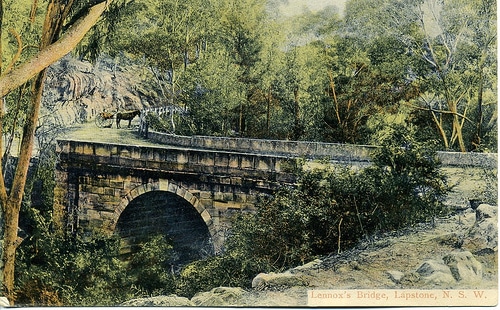 A Manvotional postcard depicts a bridge amidst the dense woods.