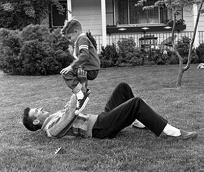 Vintage dad outside with son pushups exercise.