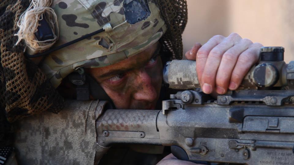 A soldier in camouflage is holding a rifle, showcasing the history of America's Special Forces.
