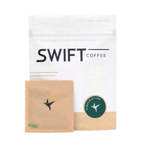 A white SWIFT Coffee package with black text, a small brown Instant Coffee packet featuring a hummingbird logo, and a green sticker labeled "Subscription," all set against a neutral background.